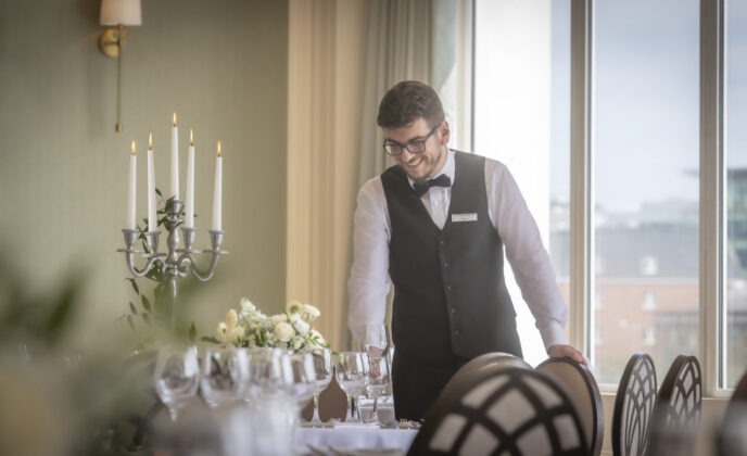Team member checking table in the Ballroom overlooking the River Lee in cork