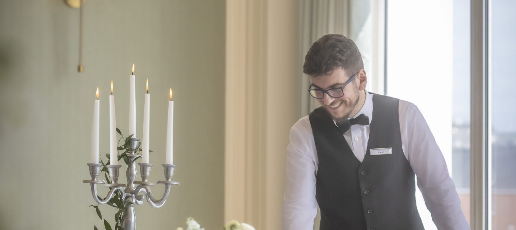 Team member checking tables for a gala dinner in the Ballroom at The Metropole