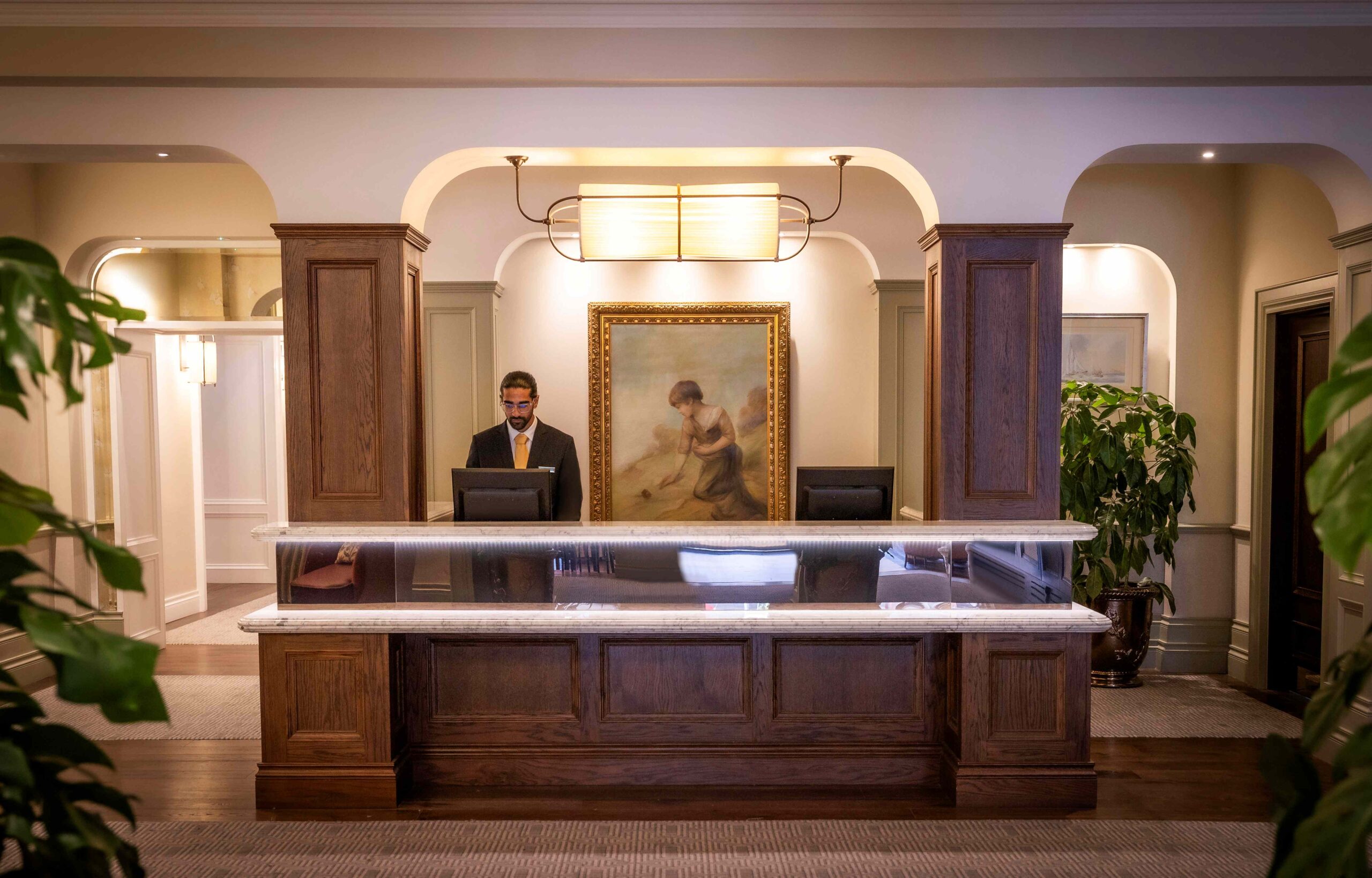 Receptionist at Metropole Hotel welcoming a guest